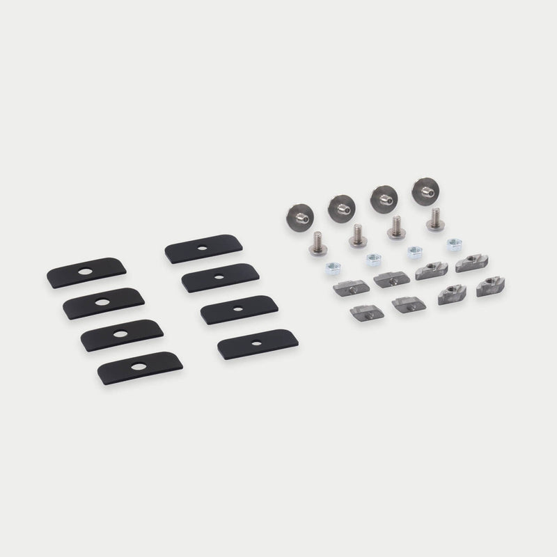 DECKED D-co Case Mounting Kit for T-Track laid out in studio: eight black backing plates, flanged bolts, hex nuts and eight M6 T-slot nuts in two styles