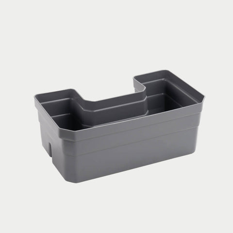 Gray DECKED Drawerganizer tray shown in studio at an angle, showing the stepped molded compartments