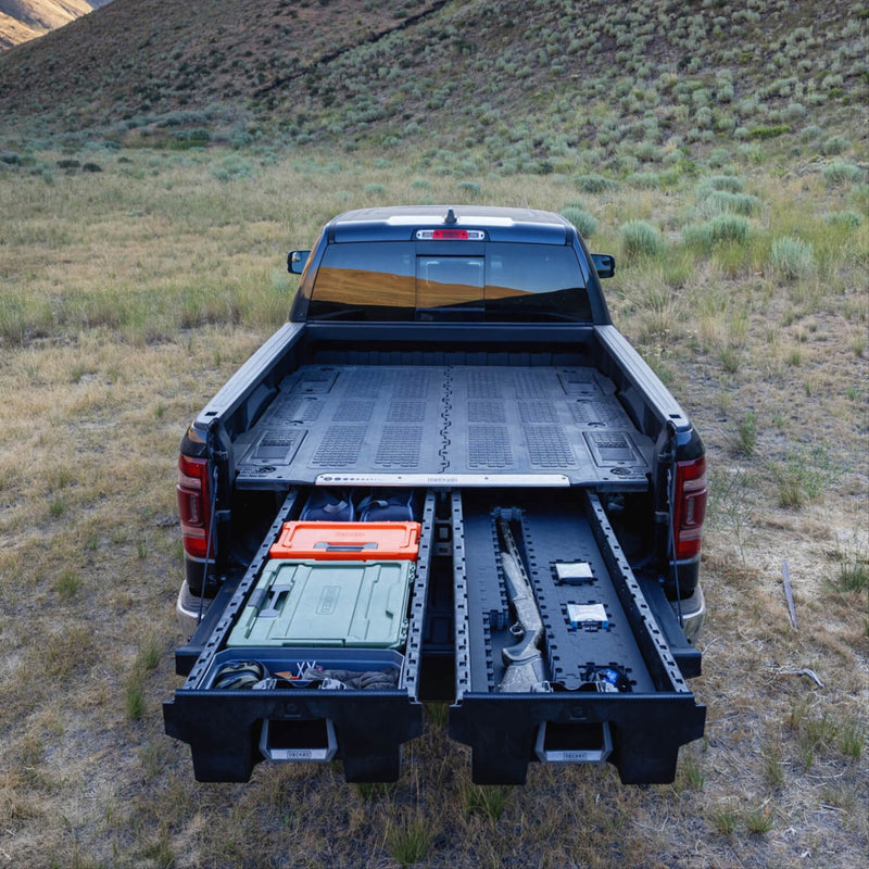 Both drawers of a DECKED Drawer System open in a Ram pickup, one drawer fitted with black Piecekeeper PuzzleFoam holding a long gun, the other holding DECKED cases