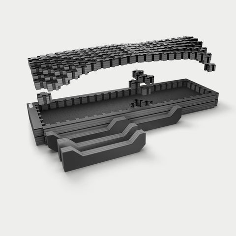 Exploded studio render of the midsize long DECKED Piecekeeper PuzzleFoam showing three stacked foam layers, the pluck-grid top sheet and two stepped brace blocks