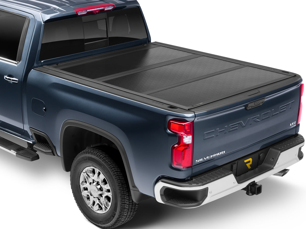 UnderCover Flex hard folding tonneau cover closed and flush across the full bed, wide rear three-quarter view showing the panel seams and low-profile rails.