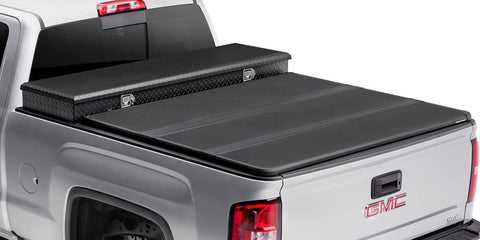 Hard folding tonneau cover closed behind a separate crossover toolbox, rear three-quarter studio view