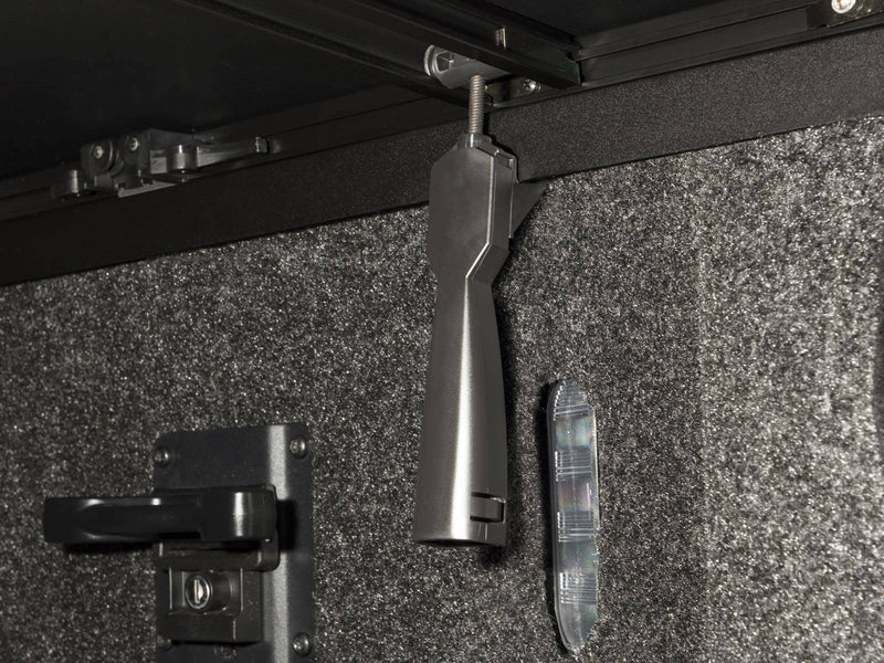 Clamp handle and tailgate latch striker mounted inside the bed