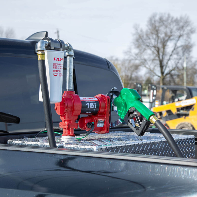 Fill-Rite FR1210HA1F 12V DC 15 GPM fuel transfer pump with filter and diesel nozzle, mounted on a diamond-plate transfer tank in a pickup bed