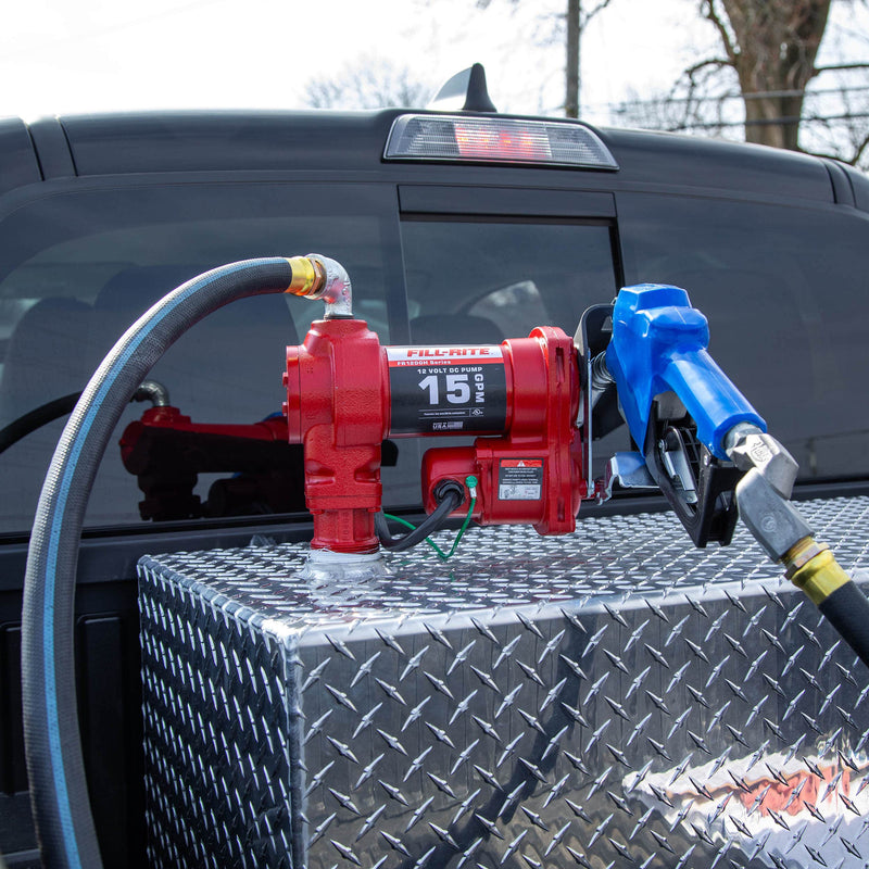 Fill-Rite FR1210HARC 12V DC 15 GPM Fuel Transfer Pump With Automatic Arctic Nozzle, mounted on a diamond-plate transfer tank in a pickup bed