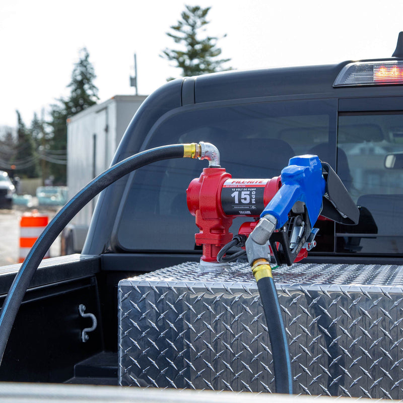 Fill-Rite FR1210HARC 12V DC 15 GPM Fuel Transfer Pump With Automatic Arctic Nozzle, mounted on a diamond-plate transfer tank in a pickup bed