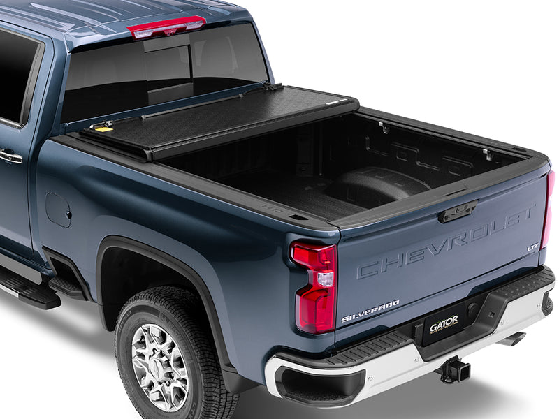 Gator EFX hard folding tonneau cover: A blue Chevrolet Silverado heavy duty with its hard cover folded toward the cab and the bed open