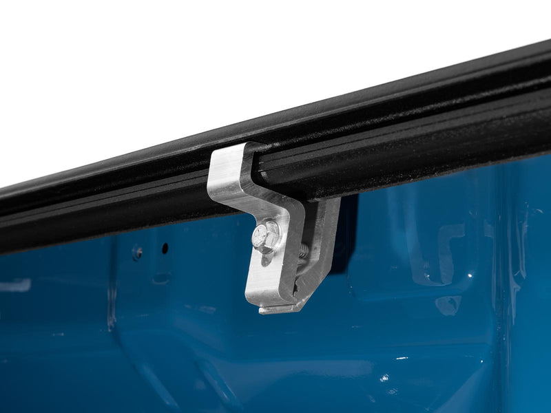 Close-up of the Gator EFX tonneau cover: close-up of an aluminum clamp hooking the black cover rail to the inside of a blue truck bed wall