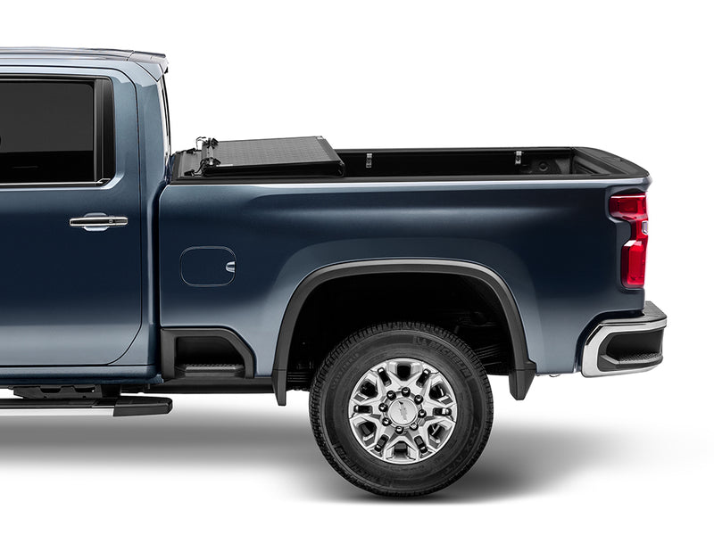 Gator EFX hard folding tonneau cover: Side view of a blue Chevrolet heavy duty pickup with the hard cover folded into a stack at the cab