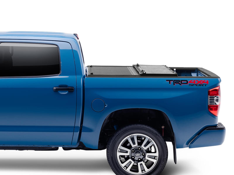 Gator EFX tonneau cover (partial) on a Toyota Tacoma: side view of a blue Toyota Tacoma TRD 4x4 Sport with the hard tri-fold cover partly folded