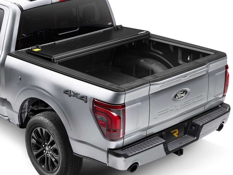 Gator EFX hard folding tonneau cover: Silver Ford F-150 4x4 from the rear three-quarter with the hard tri-fold cover folded toward the cab
