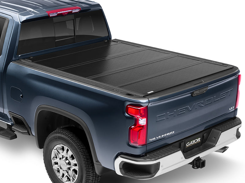 Gator FX hard folding tonneau cover: closed on a blue Chevrolet heavy-duty pickup, rear three-quarter view
