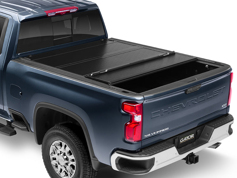 Gator FX hard folding tonneau cover: rear panel folded forward on a blue Chevrolet heavy-duty pickup