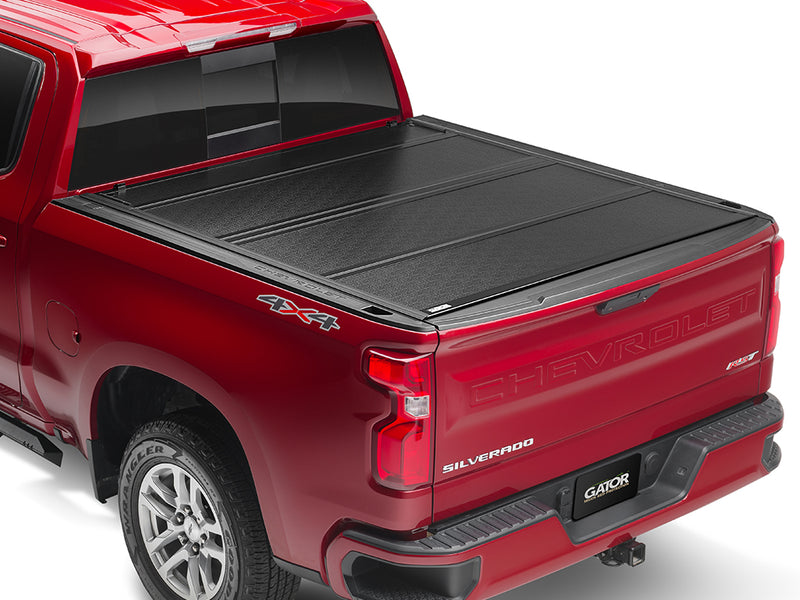 Gator FX hard folding tonneau cover: closed on a red pickup, rear three-quarter view