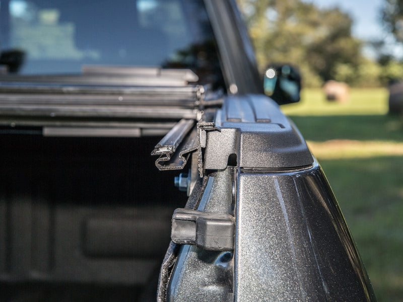 Gator FX hard folding tonneau cover: folded cover and side rail seen from the tailgate side, close-up