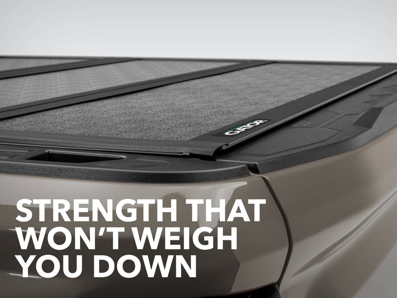 Close-up of the Gator FX tonneau cover: closed hard folding cover with Gator logo on a tan truck bed, captioned Strength That Won't Weigh You Down