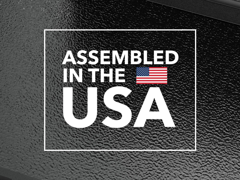 Close-up of the Gator FX tonneau cover: textured black cover panel surface overlaid with an Assembled in the USA badge and US flag
