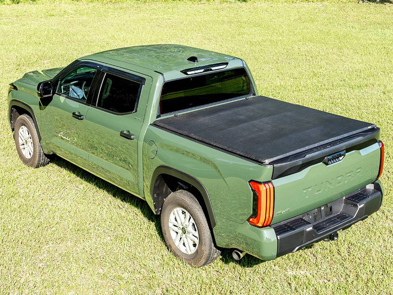 Gator SFX soft tri-fold tonneau cover: closed on a green Toyota pickup parked on grass