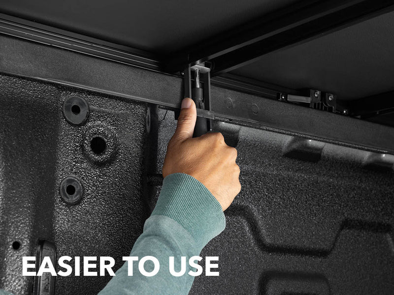 Close-up of the Gator SFX tonneau cover: A hand works the clamp under a soft cover frame in the bed, with an Easier to Use caption
