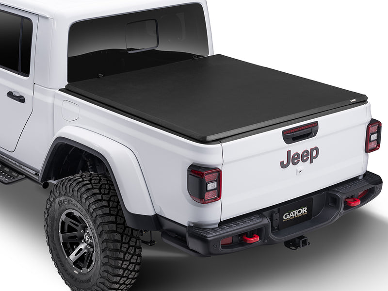 Gator SFX soft tri-fold tonneau cover: closed on a white Jeep pickup, rear three-quarter view