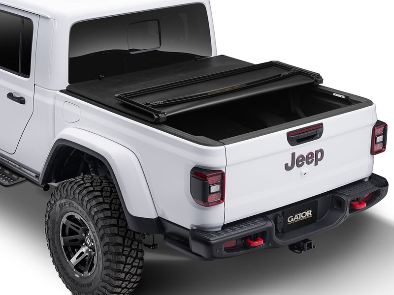 Gator SFX soft tri-fold tonneau cover: folded forward one section on a white Jeep pickup