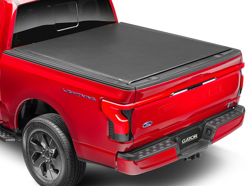 Gator SRX soft roll-up tonneau cover: A red full-size pickup with a black soft roll-up tonneau cover closed over the bed