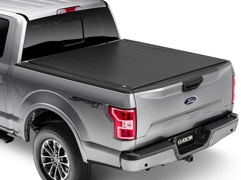 Gator SRX soft roll-up tonneau cover: A silver full-size pickup with a black soft roll-up tonneau cover closed over the bed