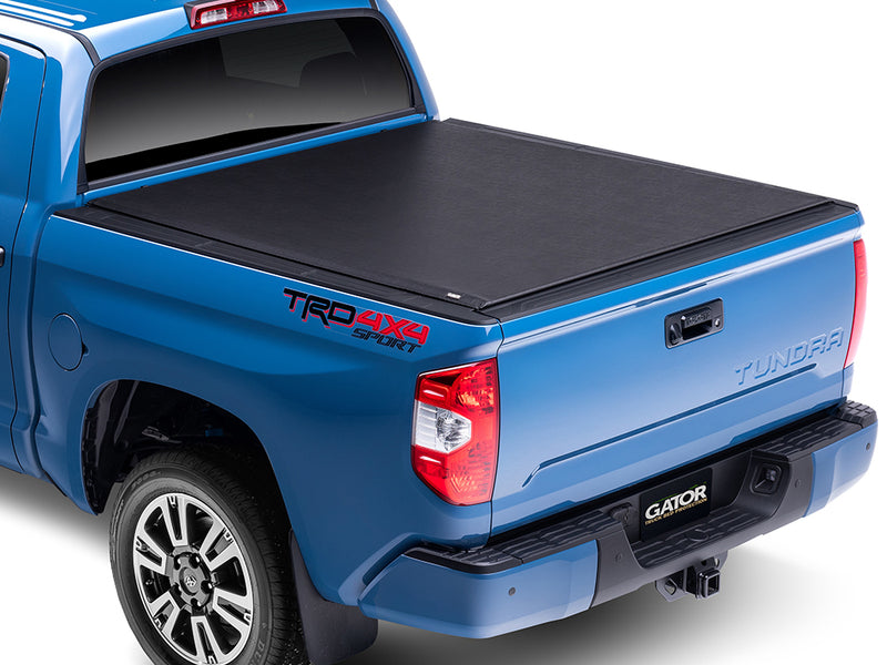 Gator SRX soft roll-up tonneau cover: Blue Toyota Tundra TRD 4x4 Sport with a black soft roll-up tonneau cover closed over the bed, rear three-quarter view