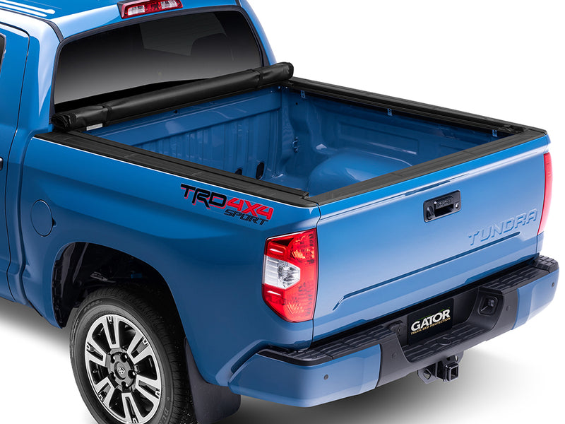 Gator SRX soft roll-up tonneau cover: Blue Toyota Tundra TRD 4x4 Sport with a soft roll-up tonneau cover fully rolled against the cab and the bed open