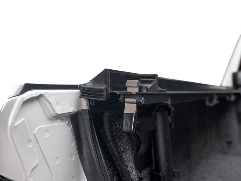 Gator SRX soft roll-up tonneau cover: Close-up of a soft roll-up tonneau rail clamp inside the bed wall of a white truck