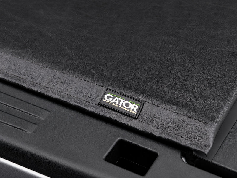 Gator SRX soft roll-up tonneau cover: Corner of a black soft tonneau cover with the Gator label above the bed rail