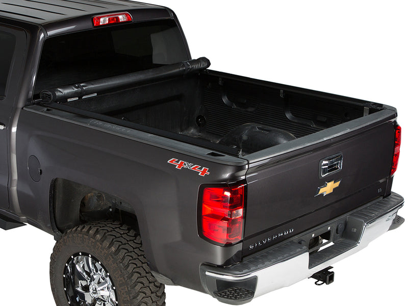 Gator SRX soft roll-up tonneau cover: Dark gray Chevrolet Silverado 4x4 with a soft roll-up tonneau cover fully rolled against the cab