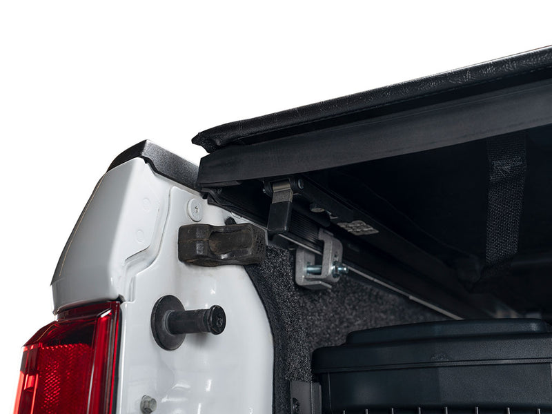 Gator SRX soft roll-up tonneau cover: Rear corner of a white Ford pickup with the soft cover partly rolled back above a carpeted bed and clamp