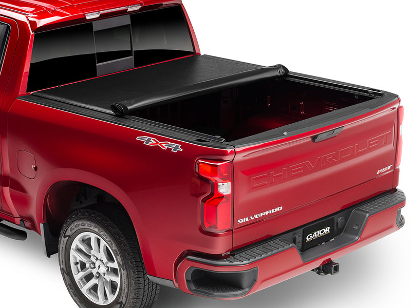 Gator SRX soft roll-up tonneau cover: Red Chevrolet Silverado 4x4 with a soft roll-up tonneau cover partly rolled toward the cab