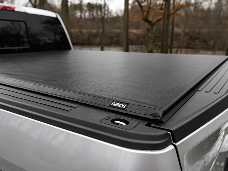 Gator SRX soft roll-up tonneau cover: The closed soft roll-up cover on a silver pickup bed outdoors, with the Gator patch near the tailgate