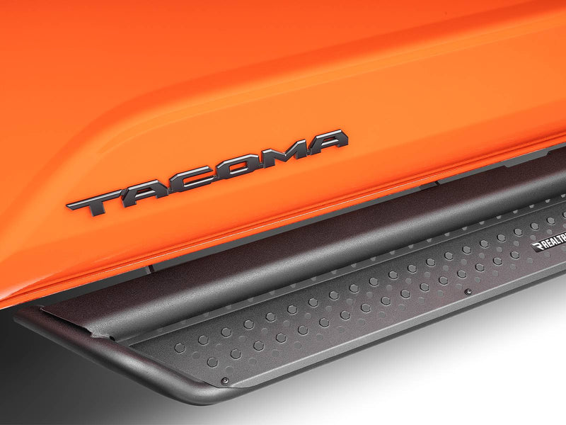 Go Rhino Dominator D1: close-up of a black side step tread under the TACOMA door lettering of an orange truck