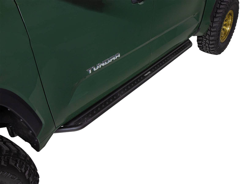 Go Rhino Dominator DSS: black slider board mounted under the door of a green pickup with TUNDRA lettering, gold wheels (shown with aftermarket gold beadlock-style wheels and mud tires, not included)