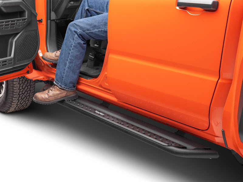 Go Rhino Dominator DSS: person in jeans and work boots stepping on a black slider board below the open door of an orange truck