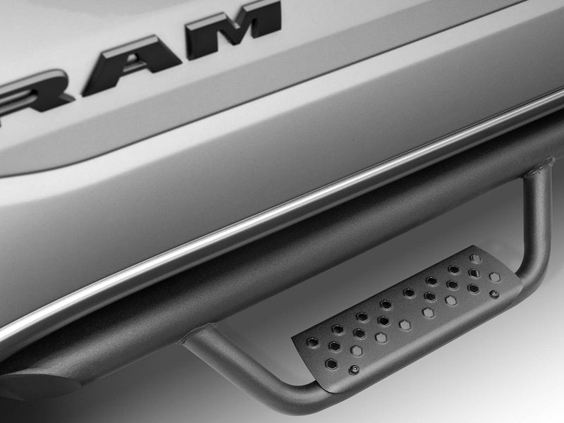 Go Rhino Dominator Xtreme D2: close-up of a black drop step pad on a tube side step below a silver door with RAM lettering