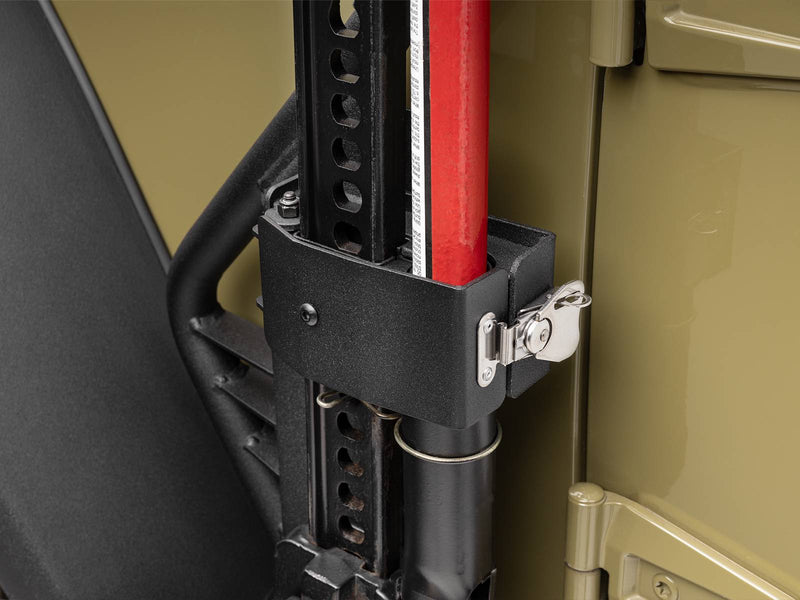 Go Rhino Exterior Jack Mount: close-up of black jack holder with latch gripping a red farm jack against an olive body panel (shown with Hi-Lift style farm jack, not included)