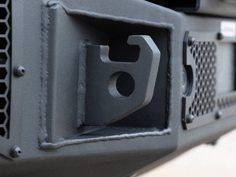 Go Rhino Rockline: close-up of a welded shackle mount in a textured black bumper beside a mesh panel