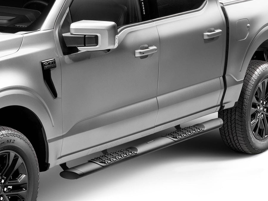 Go Rhino V-Series V3 Side Steps: Black side step with tread pads mounted under the doors of a silver pickup