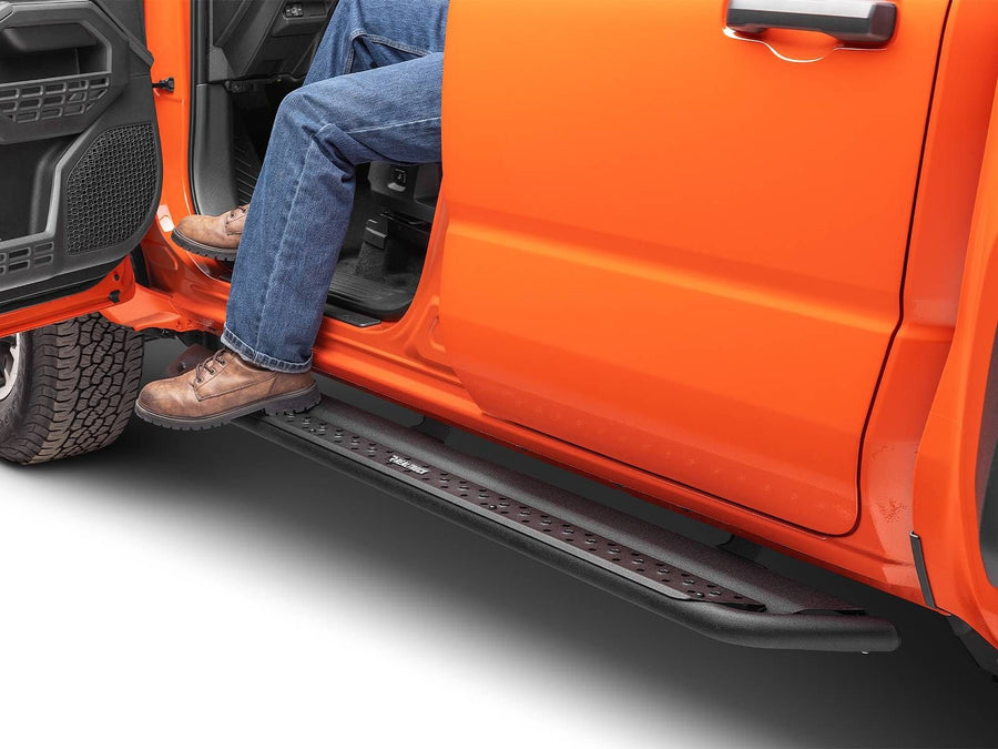 Go Rhino Dominator DSS Sliders: Person in jeans and work boots stepping on a black slider board below the open door of an orange truck