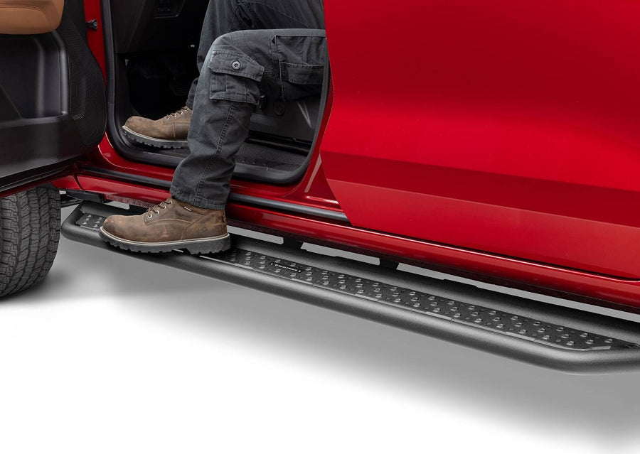 Go Rhino Dominator D6 Running Boards: Person in cargo pants and work boots stepping onto a black side step under the open door of a red truck