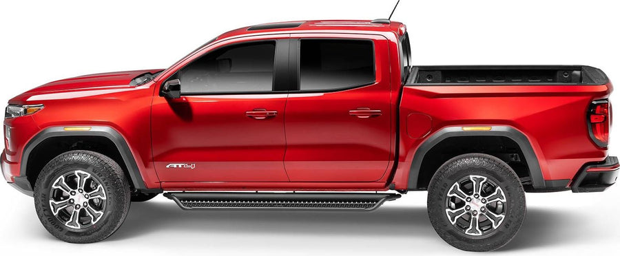 Go Rhino Dominator D1 Side Steps: Red GMC Canyon AT4 crew cab in side profile with black side steps along the cab