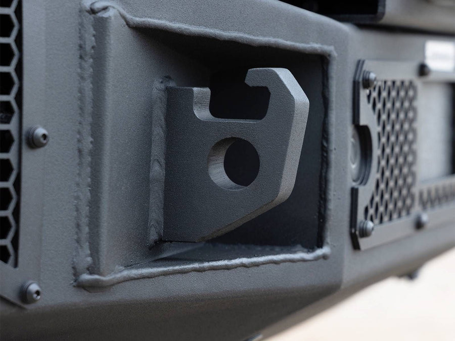 Go Rhino Rockline Full-Width Front Winch Bumper with Overrider: Close-up of a welded shackle mount in a textured black bumper beside a mesh panel