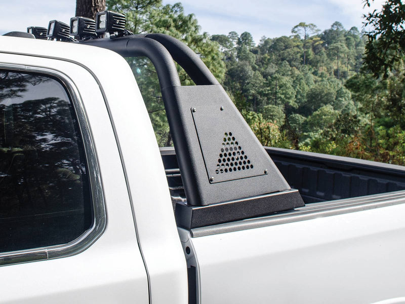 Go Rhino Sport Bar 3.0: black sport bar side post with hex vent panel on a white pickup bed, trees behind (shown with cube light pods, not included)
