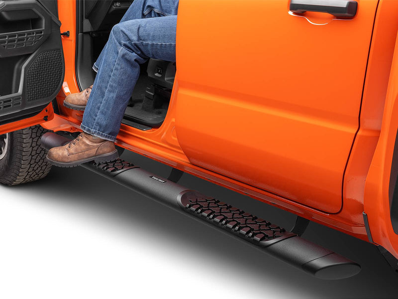 Go Rhino V-Series V3: person in jeans and work boots stepping on a black side step to enter an orange pickup