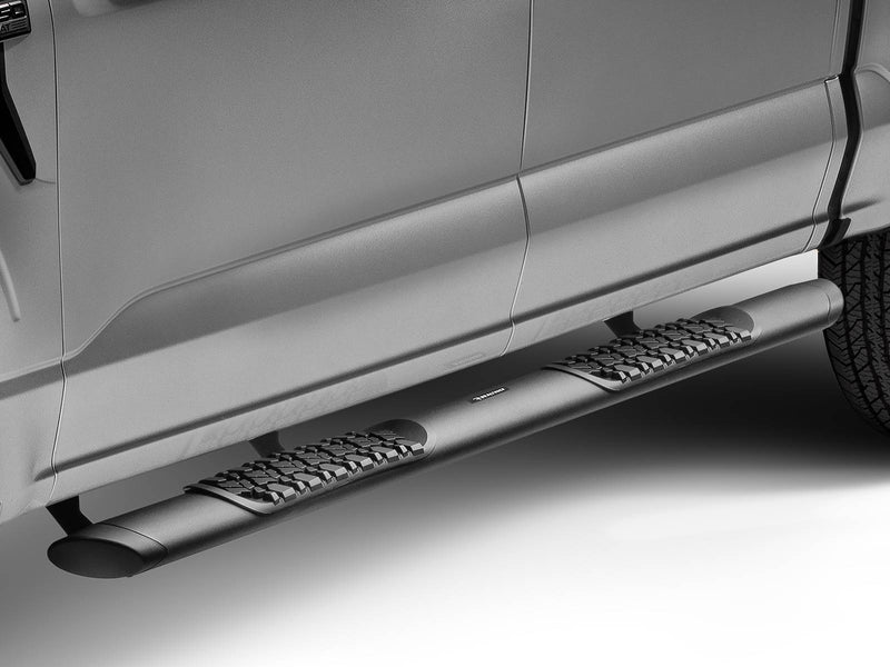 Black side step with two tread pads under the doors of a silver pickup