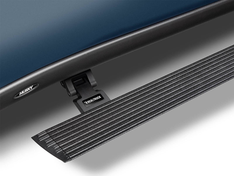 Bedliner-coated power running board deployed, close-up of the ribbed step and motor bracket (bedliner finish)